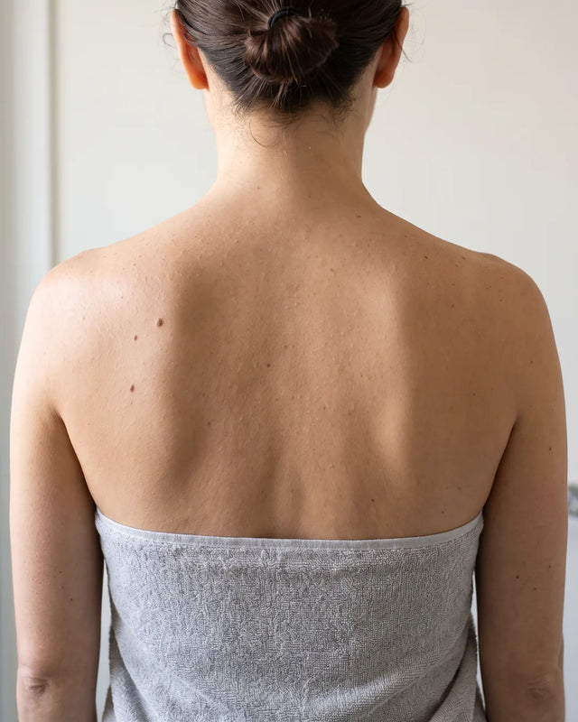 Photo d'exemple, avant : haut du dos à la peau terne et un peu rugueuse (illustration, pas un résultat client)