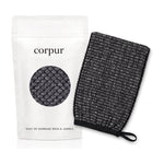 Gant de gommage bras & jambes Corpur, noir, à côté de son sachet blanc corpur
